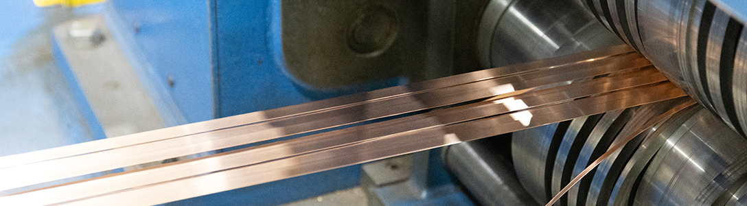 Red metal strip being processed Red metal strip being processed